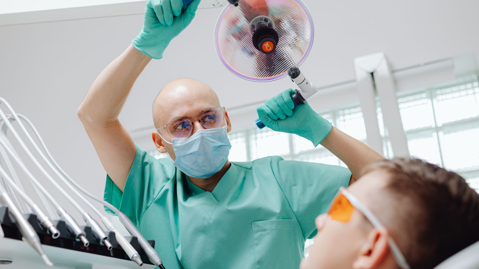 A dentist caring for a patient in a bright, modern treatment room
